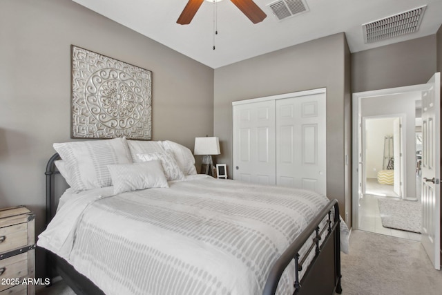 bedroom with light colored carpet, a closet, and ceiling fan