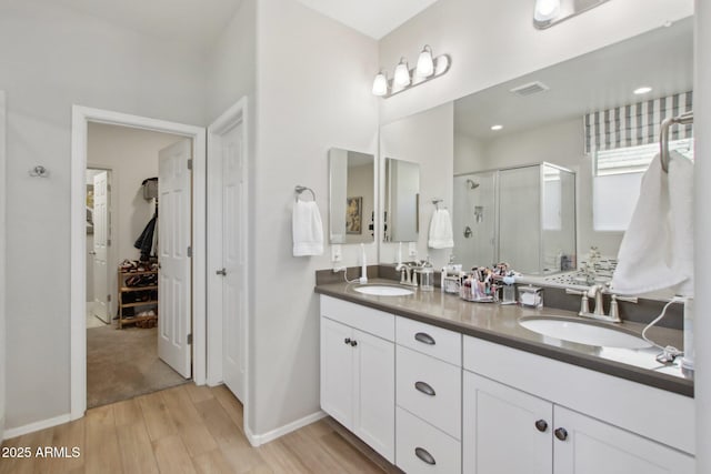 bathroom featuring vanity, hardwood / wood-style floors, and a shower with door