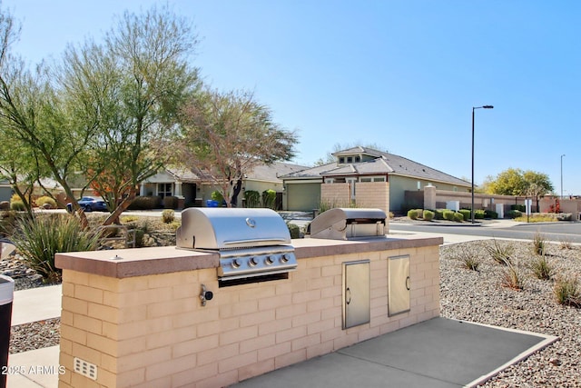 view of patio with exterior kitchen and a grill