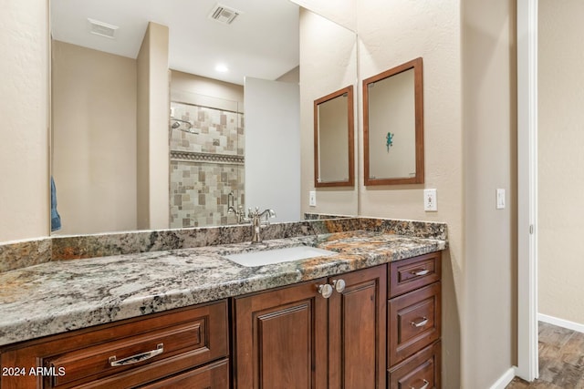 bathroom with hardwood / wood-style floors, vanity, and an enclosed shower