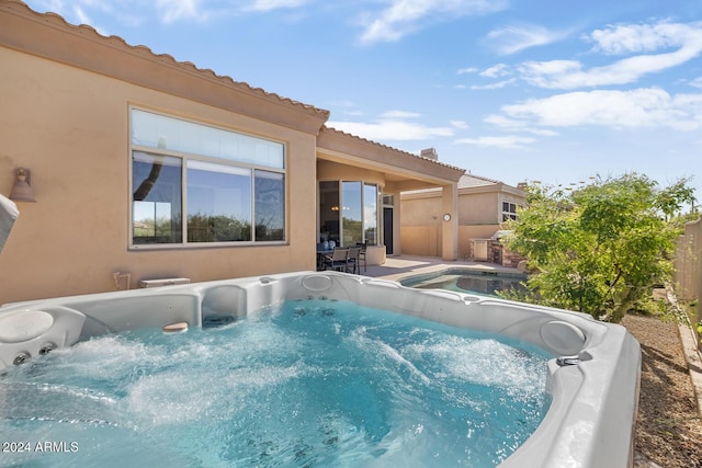 view of swimming pool with a hot tub