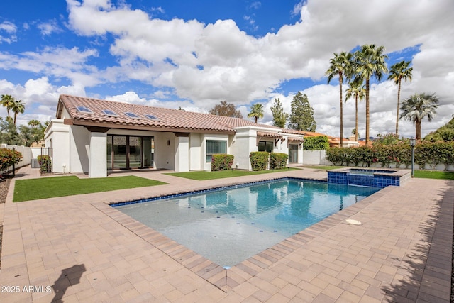 view of pool featuring a patio, a fenced backyard, a lawn, and a pool with connected hot tub