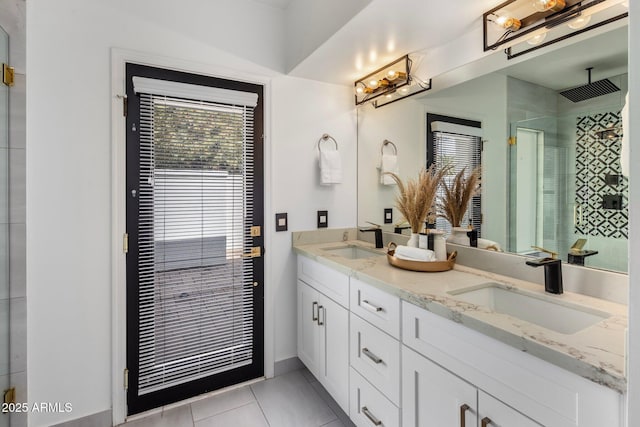 bathroom with a sink, double vanity, a stall shower, and tile patterned floors