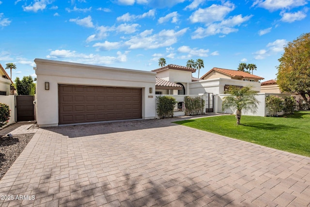 mediterranean / spanish-style house featuring a fenced front yard, a tiled roof, stucco siding, decorative driveway, and a gate