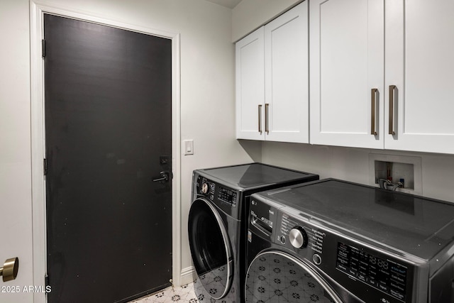 washroom with cabinet space and washer and dryer