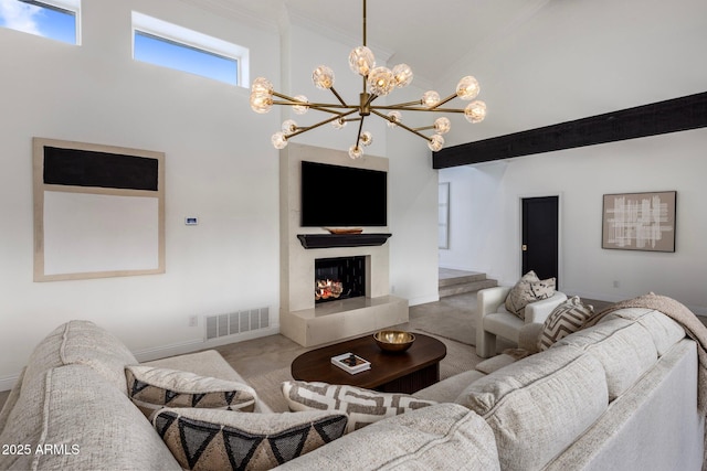 carpeted living area featuring visible vents, baseboards, ornamental molding, a warm lit fireplace, and a high ceiling