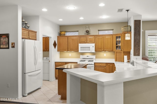 kitchen featuring washer / dryer, white appliances, hanging light fixtures, sink, and kitchen peninsula