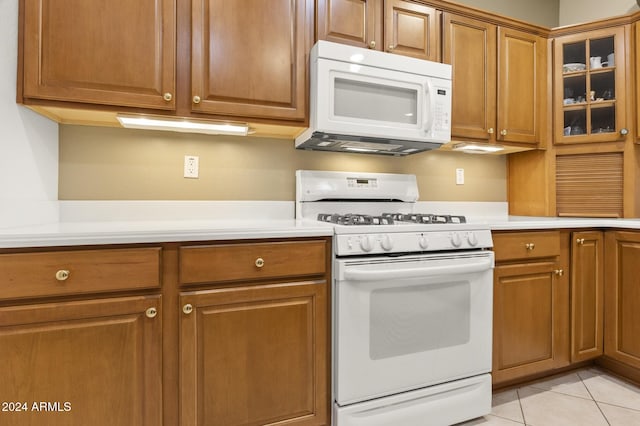 kitchen featuring white appliances and light tile patterned flooring