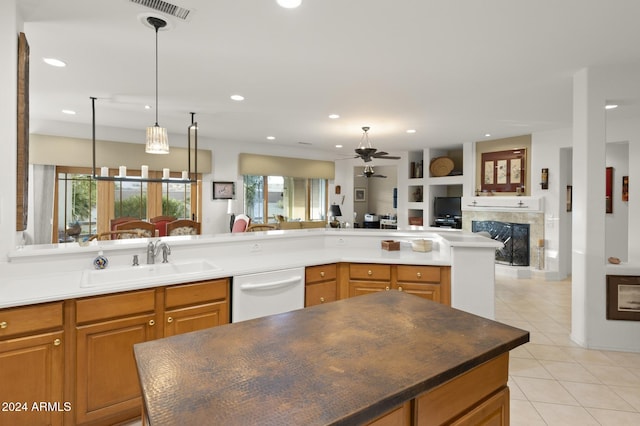 kitchen with sink, white dishwasher, ceiling fan, light tile patterned floors, and hanging light fixtures