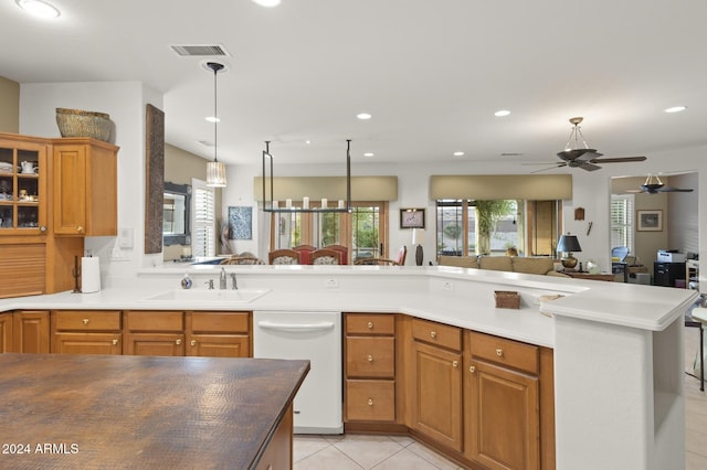 kitchen with light tile patterned flooring, sink, white dishwasher, ceiling fan, and decorative light fixtures