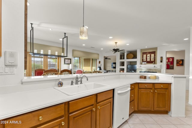 kitchen featuring dishwasher, kitchen peninsula, sink, light tile patterned floors, and decorative light fixtures