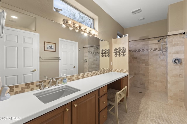 bathroom featuring vanity, decorative backsplash, and tiled shower