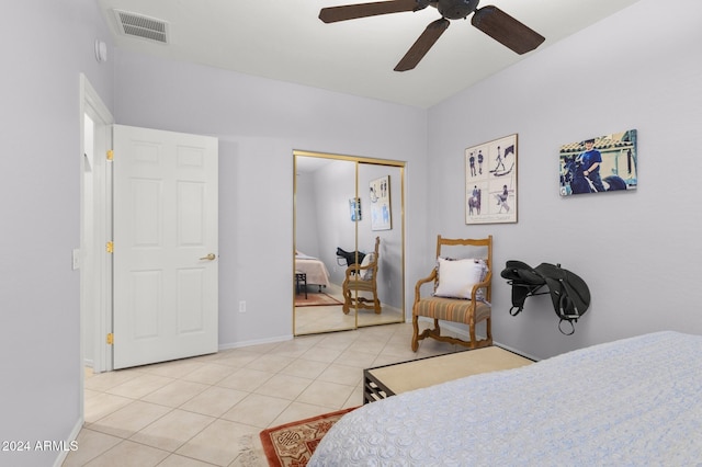 bedroom with light tile patterned floors, ceiling fan, and a closet