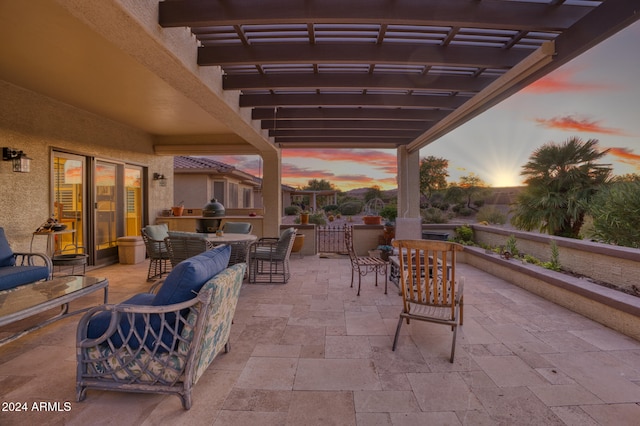 patio terrace at dusk featuring a pergola and an outdoor living space