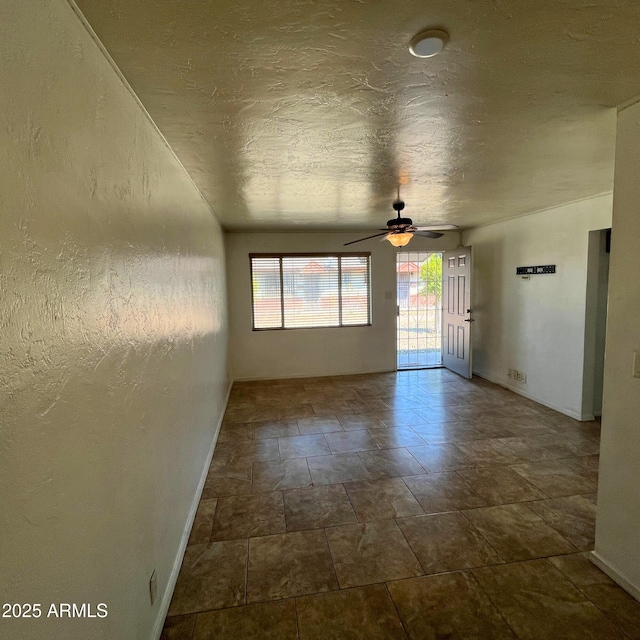 4118 N 3rd Ave, Phoenix, AZ 85013 - unfurnished room featuring baseboards, a ceiling fan, dark stone finish floors, and a textured ceiling