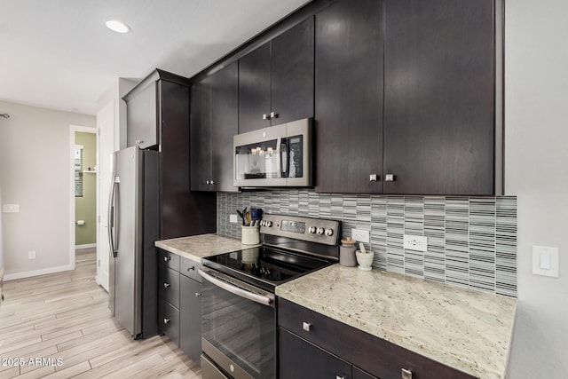 kitchen featuring stainless steel appliances, recessed lighting, decorative backsplash, light wood-style floors, and baseboards