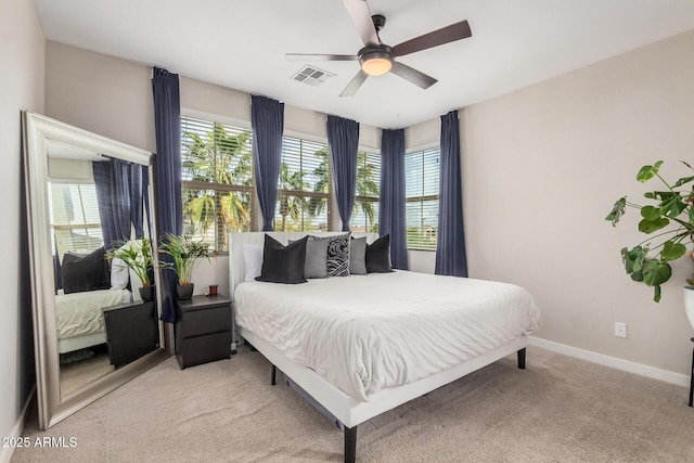 bedroom with a ceiling fan, light colored carpet, visible vents, and baseboards