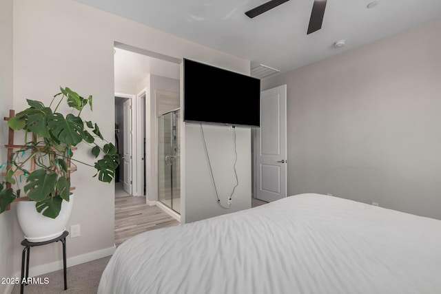 bedroom featuring light colored carpet, a ceiling fan, and baseboards