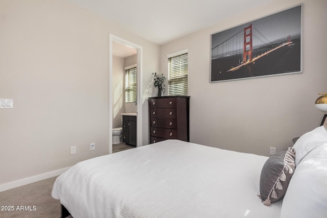 bedroom with carpet, ensuite bath, and baseboards