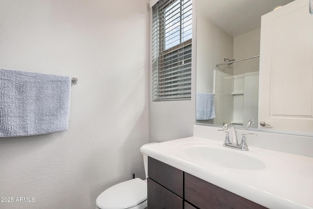 bathroom featuring walk in shower, vanity, and toilet