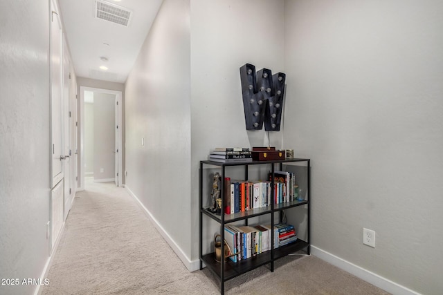 corridor with carpet, visible vents, and baseboards