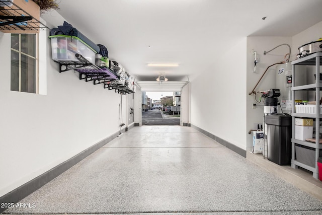 garage featuring baseboards and electric water heater