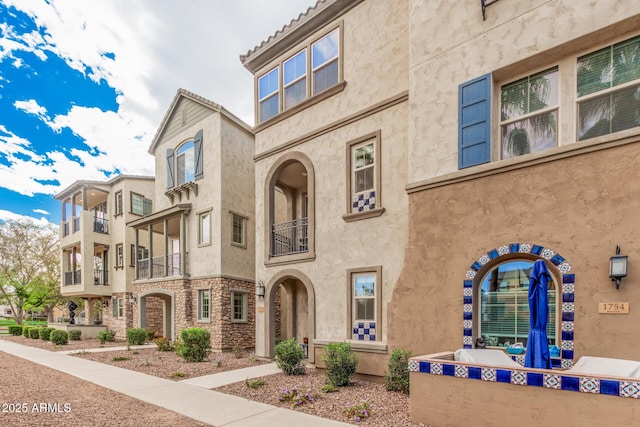 view of front of property featuring stone siding and stucco siding