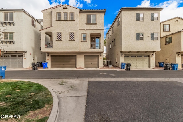 view of front of home with a garage, central AC, and stucco siding