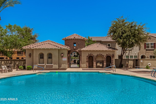 pool with fence and a patio