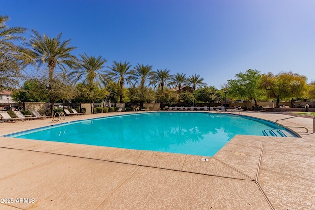 community pool featuring a patio and fence