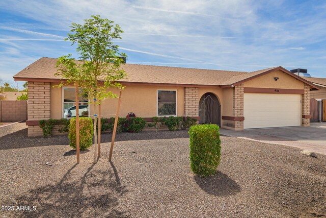 ranch-style home with driveway, brick siding, an attached garage, and stucco siding