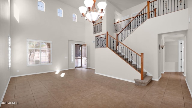 interior space featuring an inviting chandelier, tile patterned flooring, stairs, and baseboards