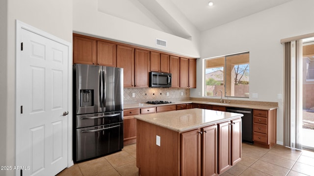 kitchen with light tile patterned floors, dishwashing machine, a sink, visible vents, and stainless steel fridge