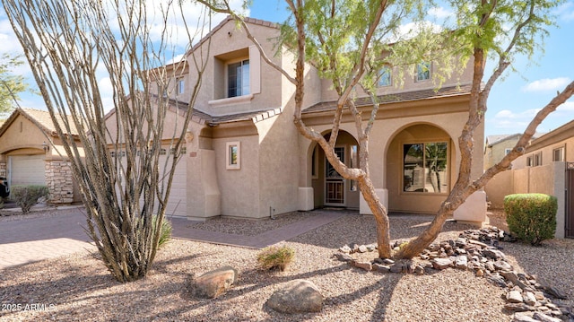 mediterranean / spanish-style house featuring decorative driveway and stucco siding