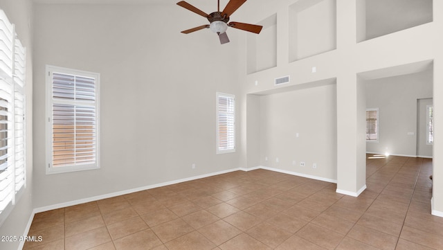 empty room with baseboards, tile patterned flooring, visible vents, and a ceiling fan