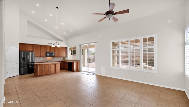 kitchen featuring light countertops, backsplash, open floor plan, light tile patterned flooring, and black appliances