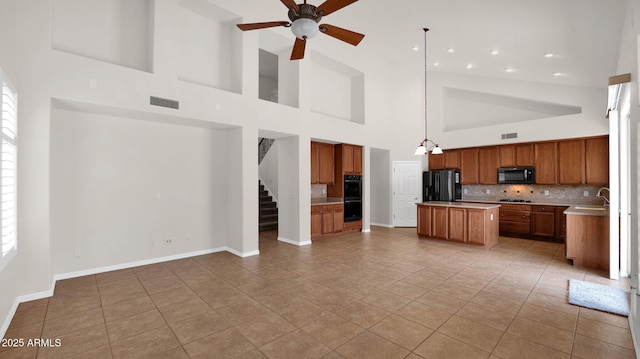 kitchen with black appliances, visible vents, brown cabinetry, and open floor plan