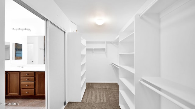 walk in closet featuring light tile patterned floors and light carpet