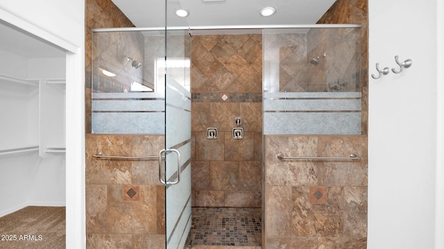 bathroom featuring a shower stall and a spacious closet