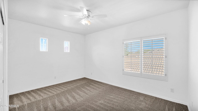 carpeted spare room featuring ceiling fan and baseboards
