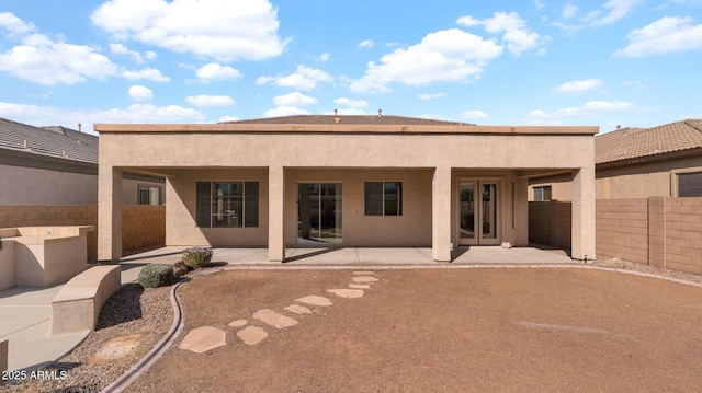 back of house with a patio area, fence, and stucco siding
