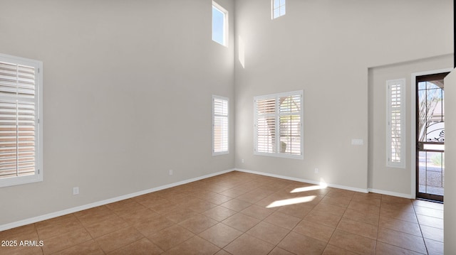 tiled foyer featuring a towering ceiling and baseboards