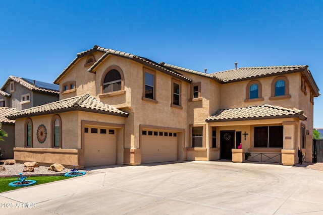 16210 W Durango St, Goodyear, AZ 85338 - mediterranean / spanish home featuring a garage, a tile roof, stucco siding, and concrete driveway