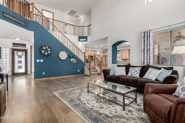16210 W Durango St, Goodyear, AZ 85338 - living room with arched walkways, wood finished floors, a towering ceiling, and stairway