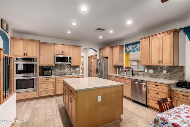16210 W Durango St, Goodyear, AZ 85338 - kitchen featuring stainless steel appliances, arched walkways, light brown cabinets, backsplash, and recessed lighting