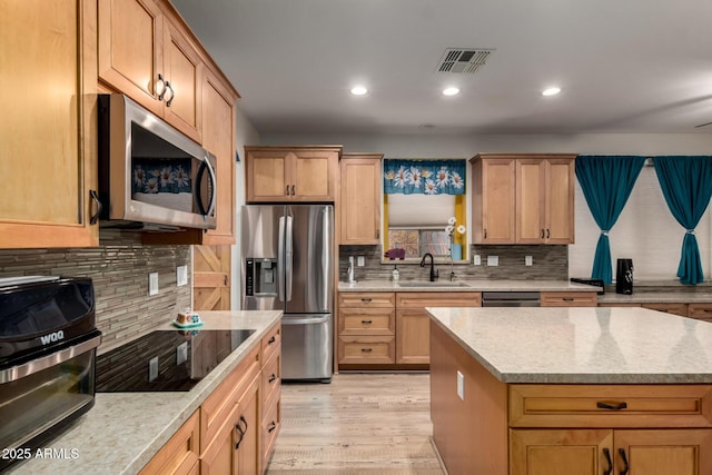 16210 W Durango St, Goodyear, AZ 85338 - kitchen with appliances with stainless steel finishes, decorative backsplash, recessed lighting, light wood-style flooring, and light stone counters