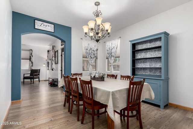 16210 W Durango St, Goodyear, AZ 85338 - dining room featuring arched walkways, wood finished floors, and a chandelier