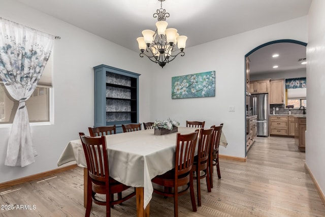 16210 W Durango St, Goodyear, AZ 85338 - dining space with light wood-style flooring, arched walkways, a chandelier, and recessed lighting