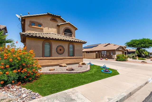 16210 W Durango St, Goodyear, AZ 85338 - mediterranean / spanish-style home with stucco siding, a tiled roof, and a front lawn