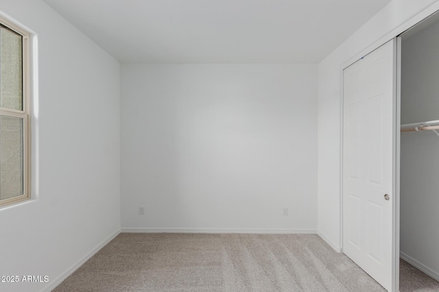 unfurnished bedroom with light carpet and a closet